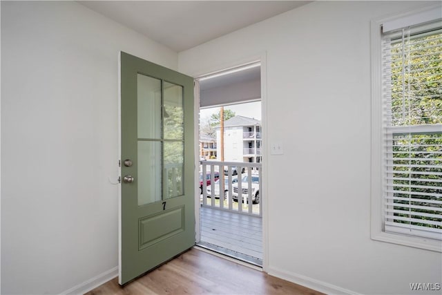 doorway to outside with baseboards and wood finished floors