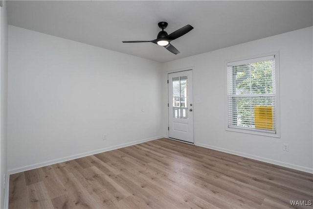 unfurnished room featuring baseboards, light wood-style floors, and ceiling fan