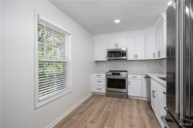 kitchen featuring white cabinetry, light wood-style floors, appliances with stainless steel finishes, and light countertops