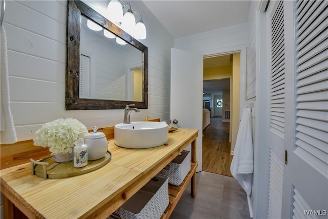 bathroom featuring wood walls and vanity