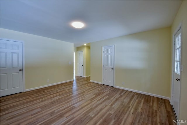 unfurnished room featuring baseboards and wood finished floors