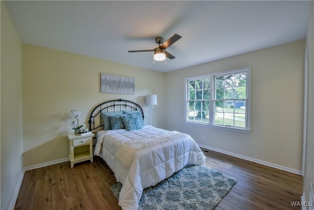 bedroom featuring wood finished floors, a ceiling fan, and baseboards