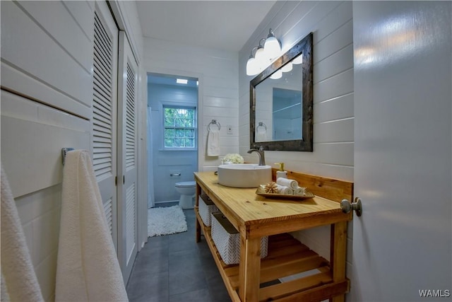 bathroom with a closet, vanity, and toilet