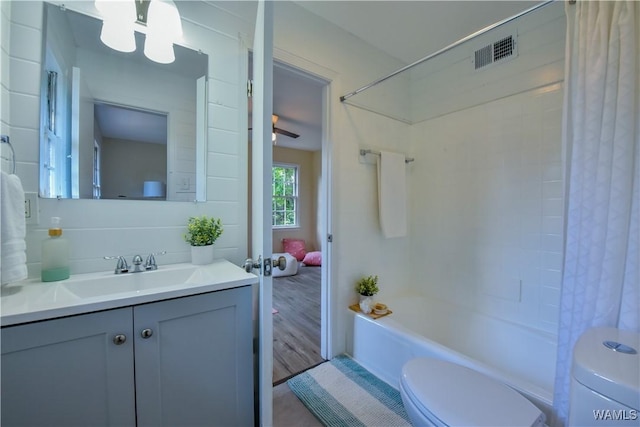 bathroom with toilet, shower / tub combo, visible vents, and vanity