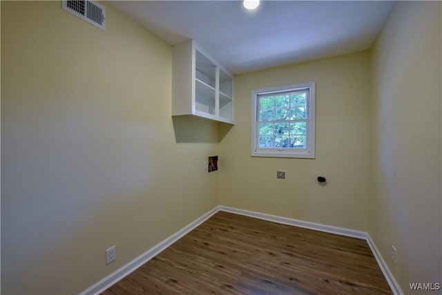 washroom with laundry area, baseboards, visible vents, and wood finished floors