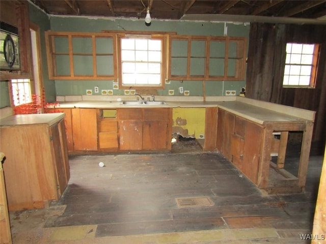 kitchen with a healthy amount of sunlight, black microwave, light countertops, and a sink