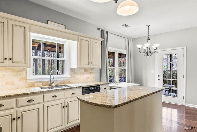 kitchen with a center island, light stone counters, sink, and tasteful backsplash