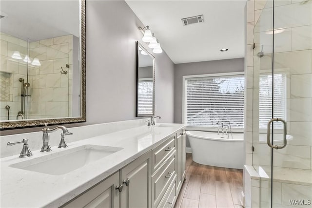 bathroom featuring hardwood / wood-style floors, vanity, separate shower and tub, and a wealth of natural light