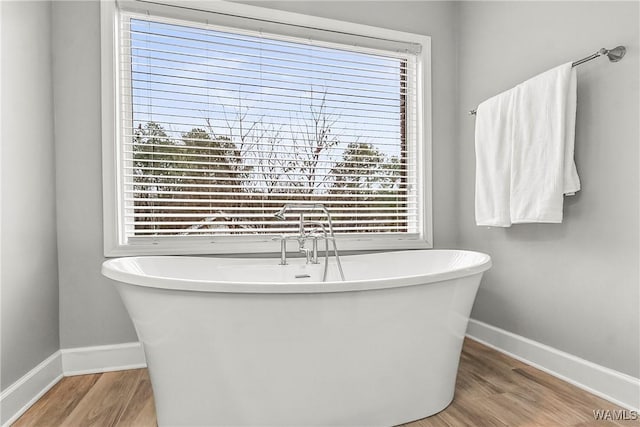 bathroom featuring hardwood / wood-style flooring and a washtub