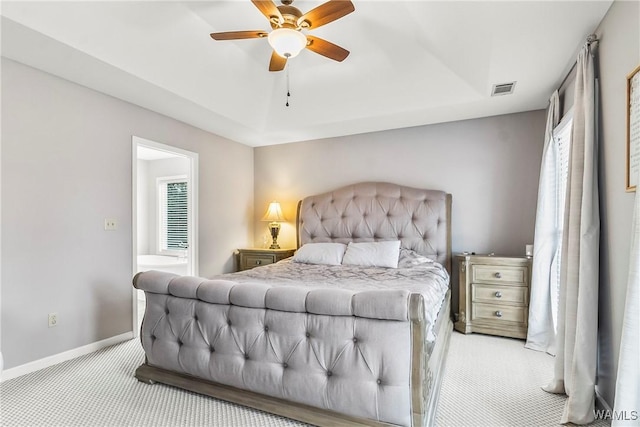 carpeted bedroom featuring a raised ceiling and ceiling fan