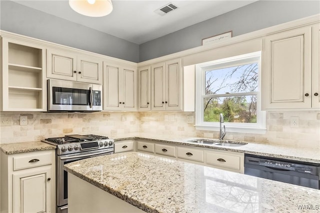 kitchen with decorative backsplash, light stone countertops, sink, and stainless steel appliances