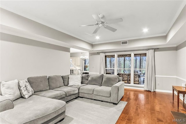 living room with hardwood / wood-style floors, ceiling fan with notable chandelier, and ornamental molding