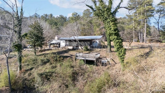view of yard with a forest view and a wooden deck