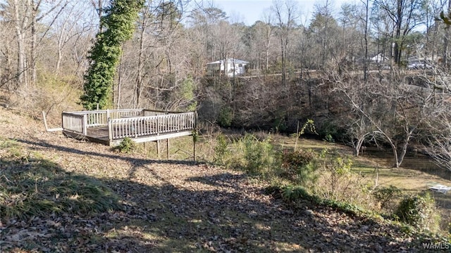 view of yard featuring a deck and a view of trees