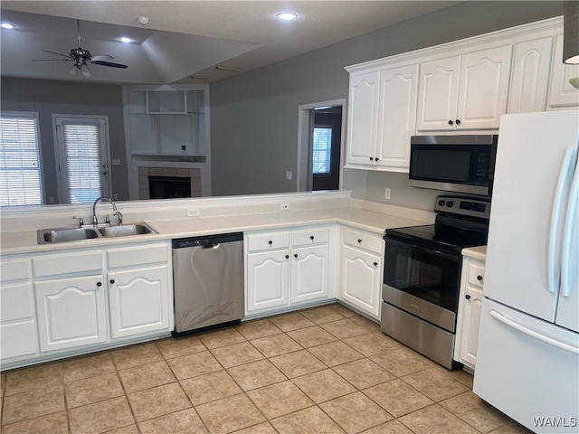 kitchen featuring light tile patterned flooring, stainless steel appliances, white cabinetry, a sink, and recessed lighting