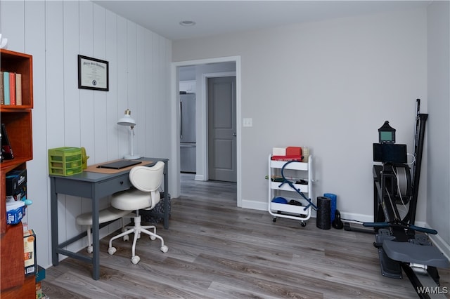 office with wooden walls and hardwood / wood-style flooring