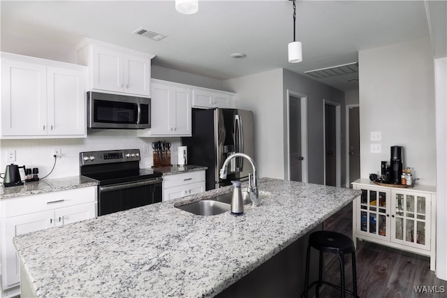 kitchen featuring sink, dark hardwood / wood-style floors, appliances with stainless steel finishes, light stone counters, and white cabinetry