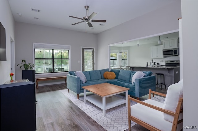 living room with ceiling fan and light wood-type flooring