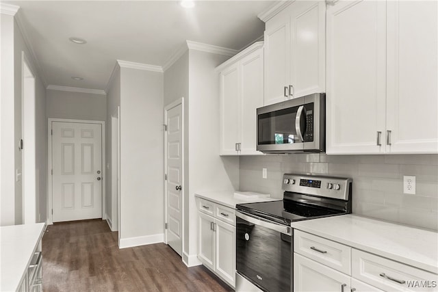 kitchen with crown molding, dark hardwood / wood-style floors, appliances with stainless steel finishes, tasteful backsplash, and white cabinetry