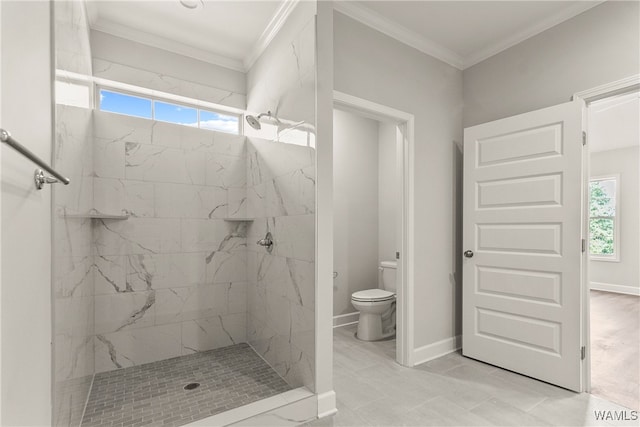 bathroom with toilet, a healthy amount of sunlight, crown molding, and tiled shower