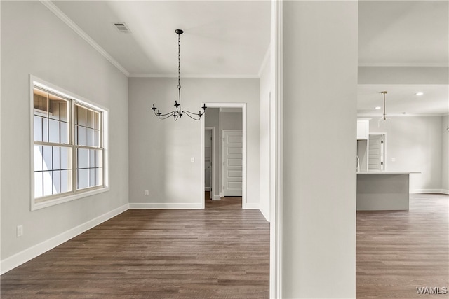 unfurnished dining area featuring a chandelier, dark hardwood / wood-style floors, and crown molding