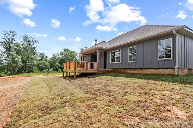 rear view of house featuring a deck and a yard