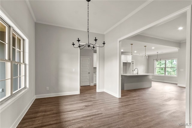 unfurnished dining area with crown molding, sink, dark hardwood / wood-style floors, and a notable chandelier