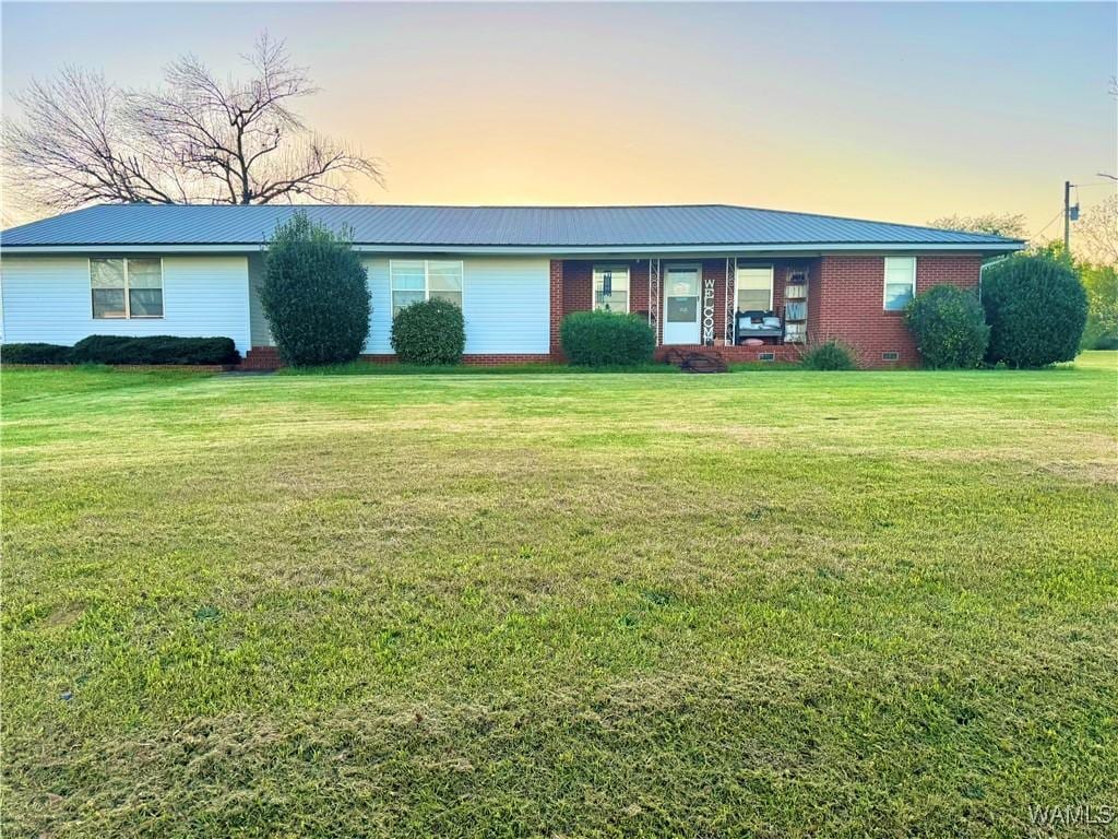single story home with a front lawn and metal roof