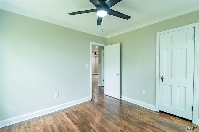 unfurnished bedroom with ornamental molding, ceiling fan, wood finished floors, and baseboards