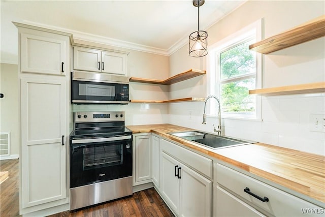 kitchen with open shelves, a sink, wooden counters, stainless steel appliances, and ornamental molding