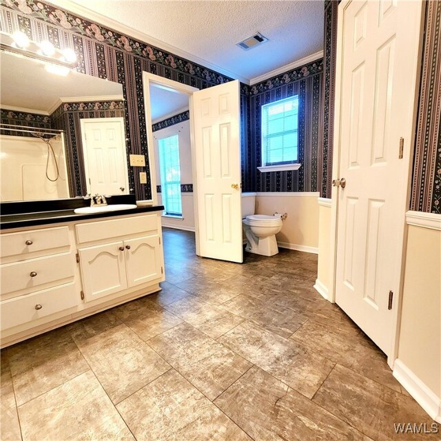 bathroom with vanity, crown molding, toilet, a textured ceiling, and walk in shower