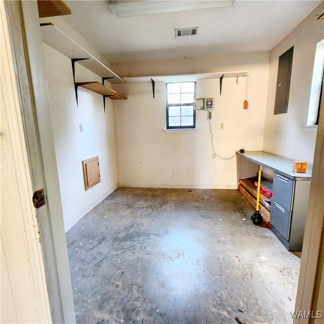 basement with electric panel and a textured ceiling