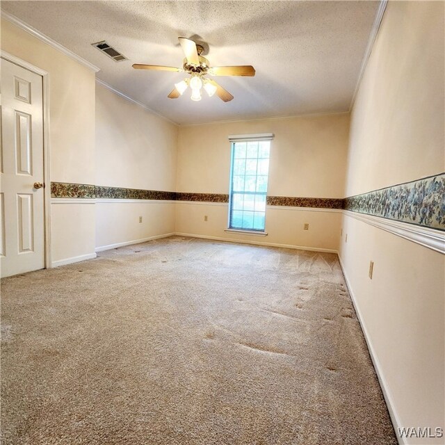 empty room featuring carpet flooring, ceiling fan, crown molding, and a textured ceiling