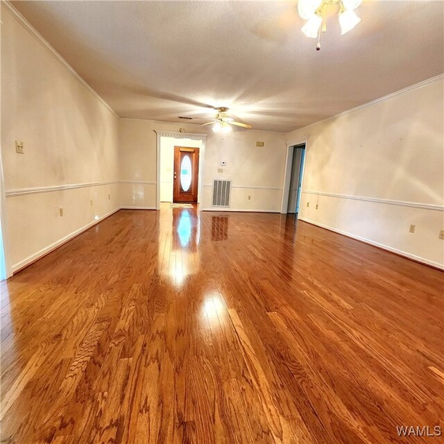 unfurnished living room featuring hardwood / wood-style flooring and crown molding