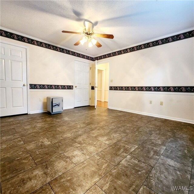 empty room with ceiling fan and a textured ceiling