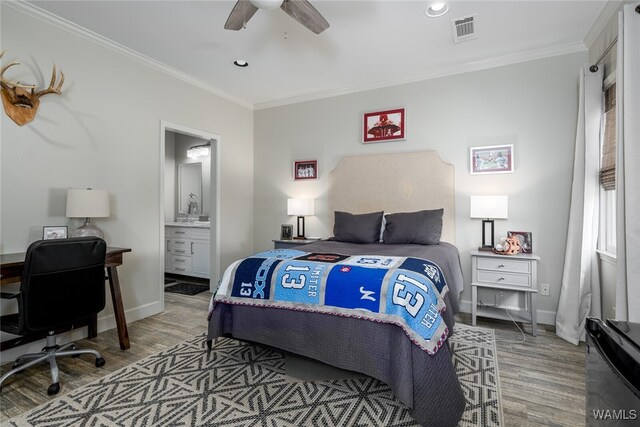 bedroom featuring hardwood / wood-style flooring, ensuite bath, ceiling fan, and crown molding