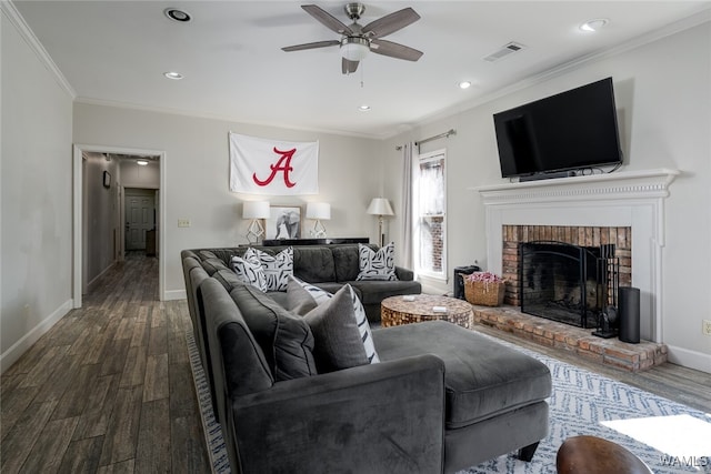 living room featuring a fireplace, hardwood / wood-style flooring, ceiling fan, and ornamental molding