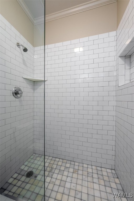 bathroom with tiled shower and ornamental molding