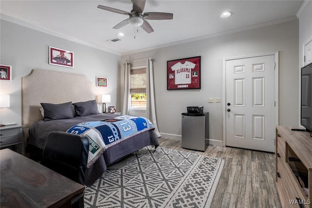 bedroom featuring ceiling fan, hardwood / wood-style floors, and ornamental molding