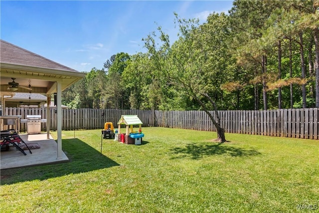 view of yard with a fenced backyard, ceiling fan, and a patio area