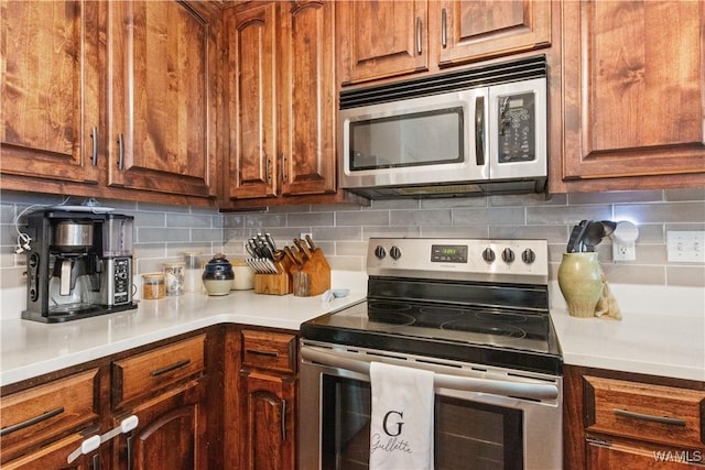 kitchen with light countertops, backsplash, brown cabinets, and stainless steel appliances