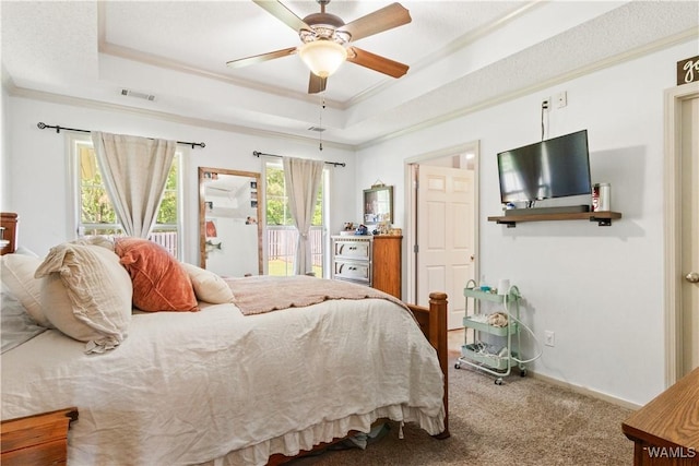 carpeted bedroom featuring a raised ceiling, access to exterior, a ceiling fan, visible vents, and ornamental molding
