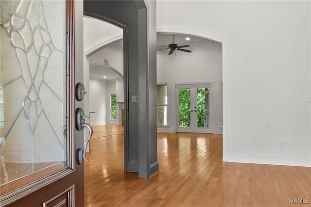 foyer featuring light wood-type flooring, ceiling fan, and crown molding