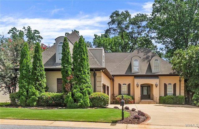 french country home with a front lawn