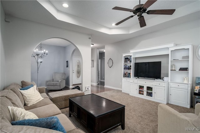 living room featuring ceiling fan, carpet flooring, and a raised ceiling