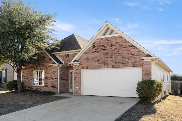 view of front of property featuring a garage, driveway, brick siding, and fence