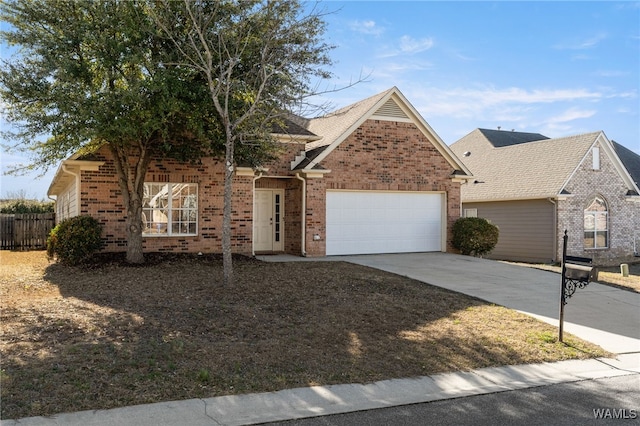 view of front of property with driveway, brick siding, an attached garage, and fence