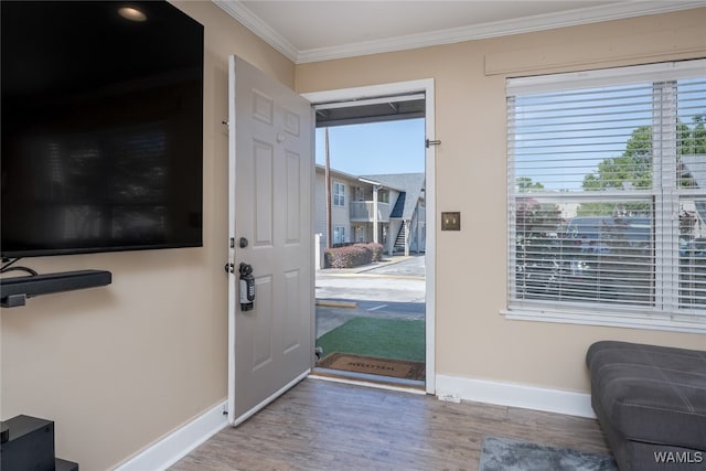 doorway with hardwood / wood-style floors and crown molding