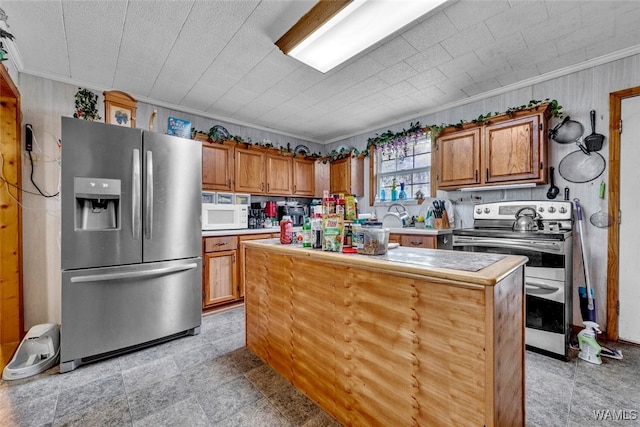 kitchen with a center island, ornamental molding, and appliances with stainless steel finishes