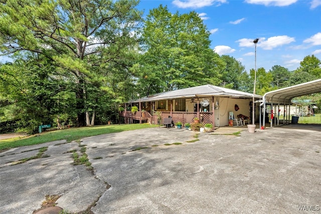 view of front of house with a front lawn, covered porch, and a carport